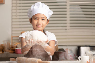 Close-up an asian little girl showing make the dough for a homemade bakery.