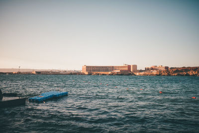 Scenic view of sea against clear sky in city