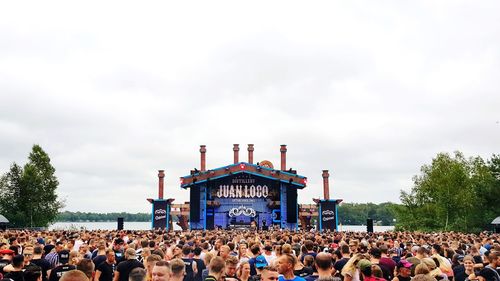 Group of people at music concert against sky