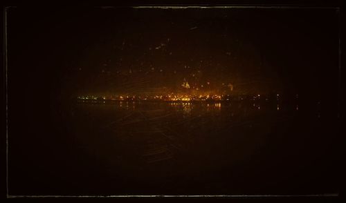 Illuminated city against sky at night