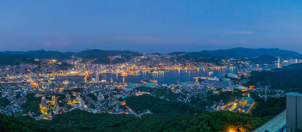 High angle view of city lit up at sunset