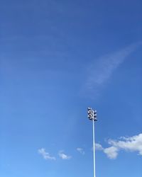 Low angle view of floodlight against blue sky