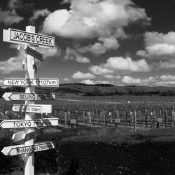 Information sign on field against sky