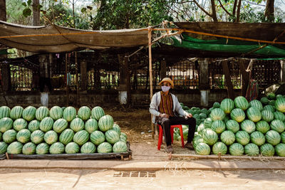 Full length of woman sitting at market stall