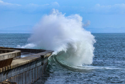 Big ocean wave hitting pier. storm waves