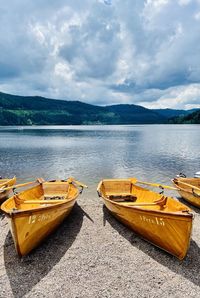 Boats moored on lake against sky