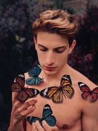 Shirtless man with colorful butterflies stickers