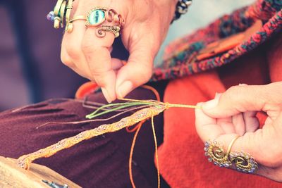 Midsection of woman tying threads