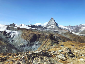 Scenic view of snowcapped mountains against clear blue sky