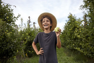 Portrait of a kid picking apples from the trees