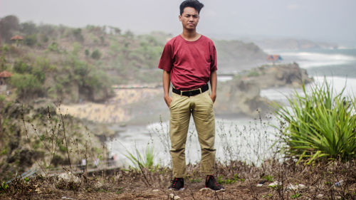 Portrait of young man standing on land