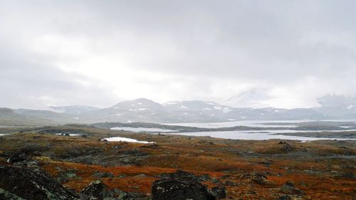 Scenic view of mountains against cloudy sky