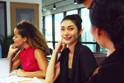 Portrait of a smiling young woman using phone