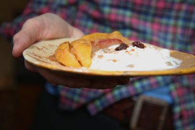 Close-up of hand holding bread in plate