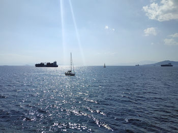 Sailboat sailing on sea against sky