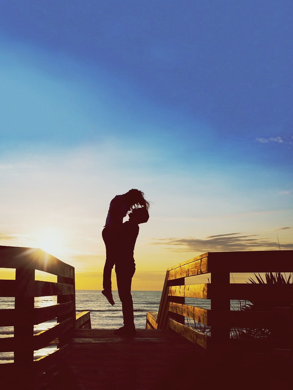 sunset, silhouette, lifestyles, standing, sky, full length, leisure activity, sea, men, railing, orange color, rear view, walking, horizon over water, person, water, togetherness