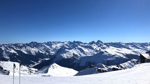 Scenic view of snowcapped mountains against clear blue sky