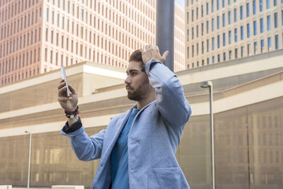 Side view of woman using mobile phone in city