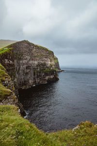 Rock formations by sea against sky
