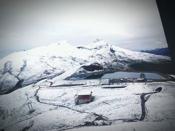 Ski lift on snowcapped mountains against sky