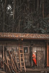 Side view of woman standing by building