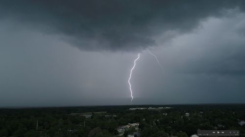 Lightning over cityscape against storm clouds