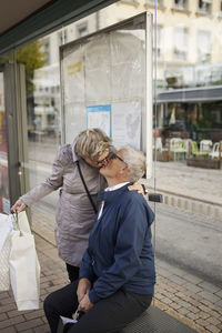 Mature couple kissing at bus stop