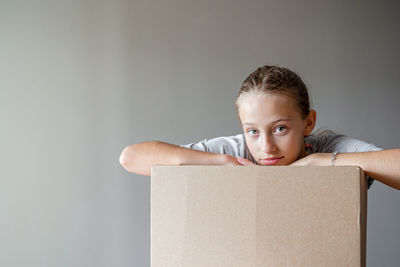 Portrait of cute boy sitting against white background