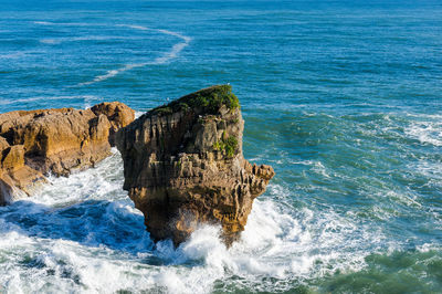 Rock formations in sea against blue sky