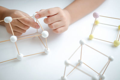 Stem education, child learning making 3d geometric shapes, building structure.