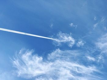 Low angle view of vapor trail in blue sky