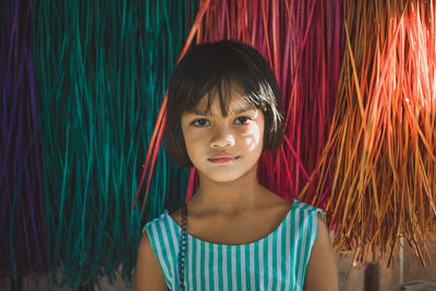 Portrait of smiling girl by curtain