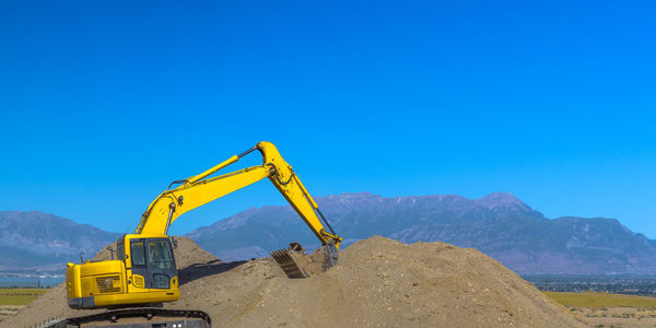 Information sign at construction site against clear blue sky