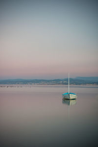 Sailboat on sea against clear sky during sunset