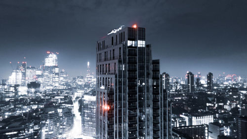 Illuminated buildings in city against sky at night