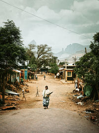 Panoramic view of people on house by building against sky