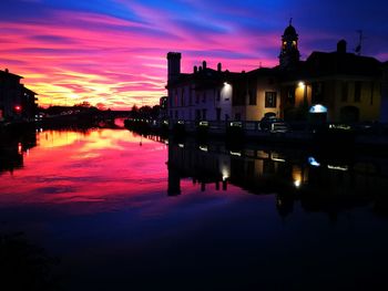 Reflection of buildings in water at sunset