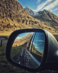 Reflection of mountains on side-view mirror