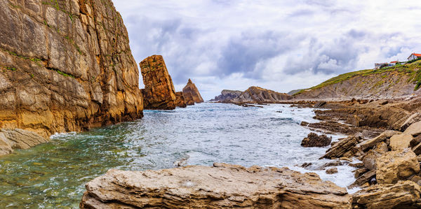 Rock formations in sea against sky