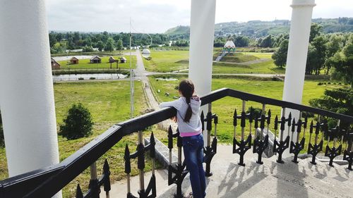 Man on field by railing against sky