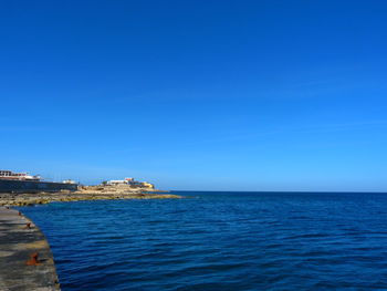 Scenic view of sea against clear blue sky