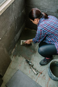 High angle view of woman sitting on wall