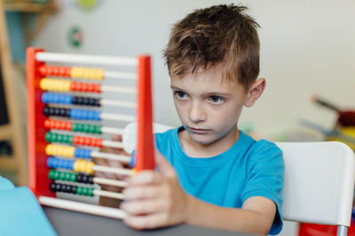 Close-up of boy using abacus