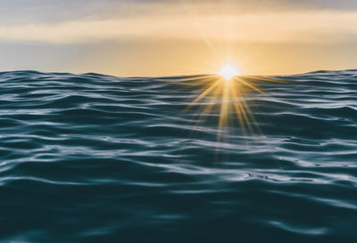 Surface level of swimming pool against sky during sunset