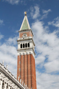 Low angle view of bell tower against cloudy sky