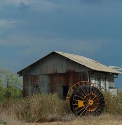 View of field against cloudy sky