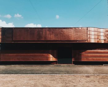 Exterior of brown metal building against sky