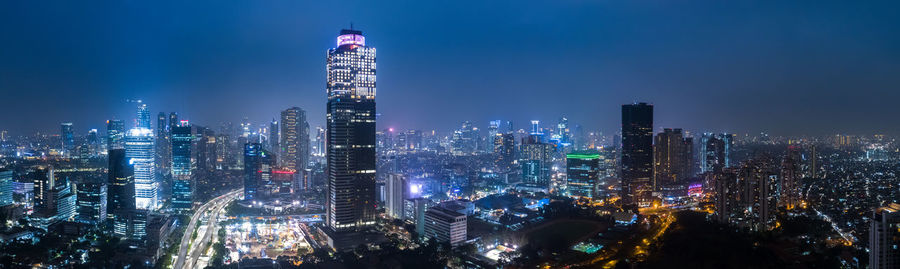 Panoramic view of illuminated buildings against sky at night