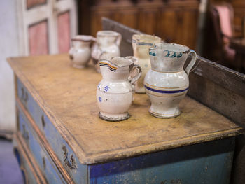 Decorative handmade porcelain vases on top of an antique wooden furniture.