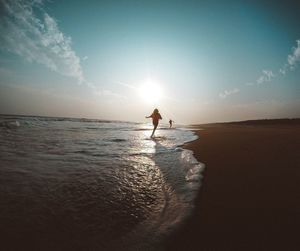 Silhouette man on beach against sky